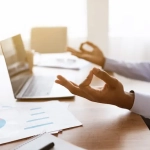 main d'une personne en position zen à son bureau